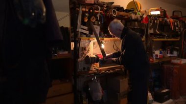 Dedem atölyesinde bir balta keskinleştirir. Aletlerle dolu rahat bir atölyede, yaşlı bir zanaatkar, sıcak bir lambayla aydınlatılan, özverili bir dikiş makinesini dikkatlice ayarlar..