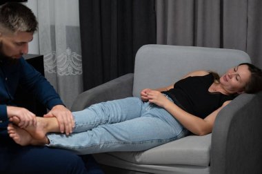 Yumuşak ışıklandırma, yetenekli bir terapist, müşterinin yoğun bir günden kurtulmasına ve iç huzurunu bulmasına yardımcı olan belalı bir ayak masajı yaptığı için huzurlu bir atmosferi güçlendirir..