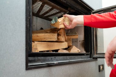 Eller ustalıkla ahşap parçalarını parlak bir odun sobasının içine yerleştirir, serin bir öğleden sonra sıcak ve davetkar aromalarla çağdaş yaşam alanını doldurur..