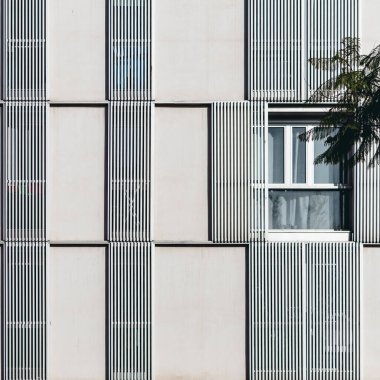 Simetrik geometrisi ve penceresi olan bir binanın ön cephesi