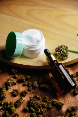 Marihuana CBC ve TGC. Marihuana tomurcukları masada. Petrol için kavanoz, pipetli kozmetik. Marihuana ile krema ve kozmetik