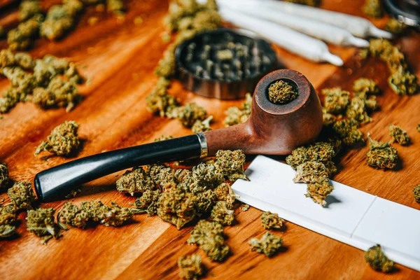 大麻毒品在木制桌子上烟斗 研磨机和Cbd Sativa或Indica Tgk芽 关节用纸 — 图库照片