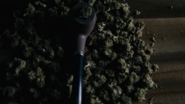 Masada marihuana içmek için kullanılan tahta pipo Cbd sativa veya indica tgk tomurcuklarının arka planına karşı. Uyuşturucu ve ilaç.
