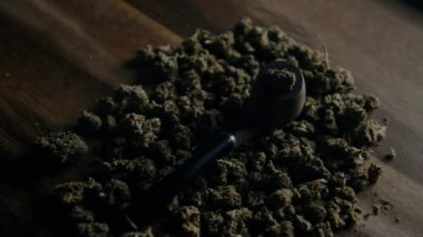 Masada marihuana içmek için kullanılan tahta pipo Cbd sativa veya indica tgk tomurcuklarının arka planına karşı. Uyuşturucu ve ilaç.