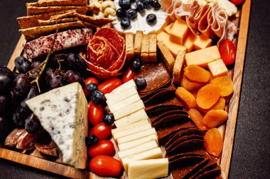 Peynir tabağı, peynir tahtası eti ve yiyecek. Sebze ve meyveli peynir ve çikolata, jambon ve salamlı ekmek. Parti için büyük bir atıştırmalık tahtası..