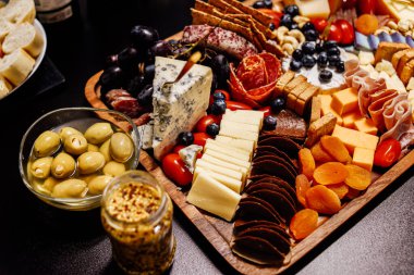 Peynir tabağı, peynir tahtası eti ve yiyecek. Sebze ve meyveli peynir ve çikolata, jambon ve salamlı ekmek. Parti için büyük bir atıştırmalık tahtası..