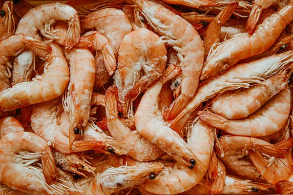 Shrimps are frozen in large quantities, seafood is fresh, many with ice. Fresh shrimps, fish department