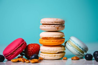 Renkli badem kurabiyeleri, pastel renkler, eski kart, üst manzara. Turkuaz arka planda pasta ya da badem kurabiyesi.