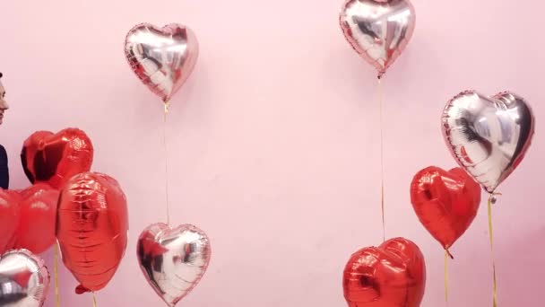 バレンタインデーの美しいカップルは2月14日 愛を祝います 女と男は風船の後ろにキス赤い心 ロマンチックなデート かわいい — ストック動画