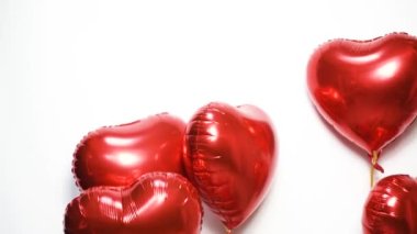 Kırmızı bir kalp şeklinde balonlar var. Sevgililer Günü 'nü kutluyoruz. Havada ve havada mesaj, tatil, havada uçmak için bir sürü balon var. Kadınlar Günü, evlilik teklifi, düğün.