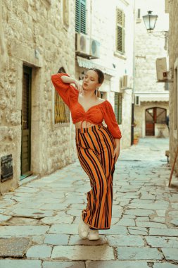 Çok güzel bir kadın Avrupa 'da seyahat ederken eski bir şehrin sokaklarında poz veriyor. Avrupa 'da tatil ve tatil. Tarzı olan güzel bir kız