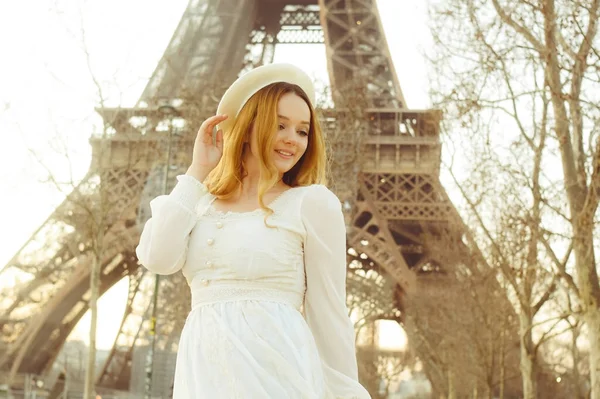 パリのエッフェル塔を背景にベレー帽をかぶった女の子とカールした髪のドレス ロマンチックな旅 笑う女と目を離す女 — ストック写真