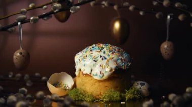 Homemade Easter cake, colored sprinkles in a shell. Quail eggs in hay, restaurant serving food. Easter and holidays on brown, Pussy willow, interesting decorations from golden eggs. Restaurant serving food on moss