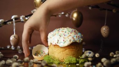 Easter cake is decorated with colored sprinkles made from egg tartup. Pussy willow on a brown background, Easter and recipes, home cooking and celebration, baking. Serving food in a restaurant on moss