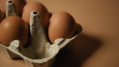 Paskalya yaklaşıyor, dişi bir el tepsiden bir yumurta alıyor ve kahverengi arka planda altın bir Paskalya yumurtası bırakıyor. Kutlamalar ve gelenekler