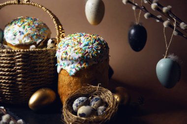 Easter cakes with colored sprinkles, colored golden eggs, and pussy willow decorations. Nest with eggs, Traditions