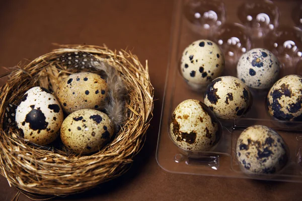 A woman\'s hand transfers quail eggs from a small nest into a plastic package. Homemade eggs, accessories and food. Eco quail eggs on brown color, farm and quality products.