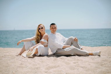 Aşıklar gökyüzüne, okyanusa, tepeye, güneşin altına bakarlar. Tatil, turizm, balayı. Uzun saçlı kız.. 