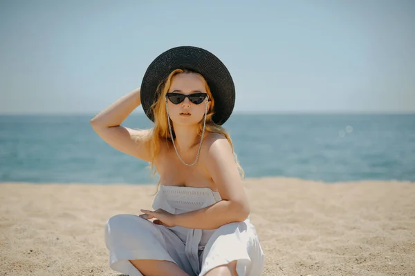 안경을 소녀의 사진입니다 과커다란 밀짚모자를 바다나 바다를 배경으로 해변에서 일광욕을 로열티 프리 스톡 사진