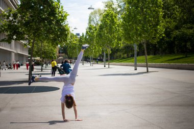 Milan, Lombardy, İtalya - 5 Mayıs 2024: Pasternak gezinti alanında günümüz Feltrinelli binası boyunca bir tur atan okul kızı.