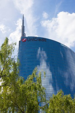 Milan, Lombardy, İtalya - 5 Mayıs 2024: Milano 'daki çelik ve cam gökdelen Unicredit Kulesi, Porta Nuova bölgesinde ağaçlarla çevrili....