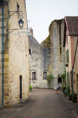 Entrance tower, cobbles street and half-timbered houses in the medieval village of Mennetou-sur-Cher, France. Vertical shot. clipart