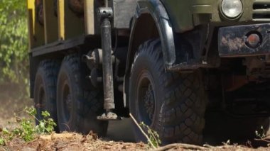 Ağır çekimde yakın çekim, büyük kereste kamyonu çekimleri, ağaçları kesmeler, yoldan toz kaldırmalar, büyük tekerlekli kamyonlar.