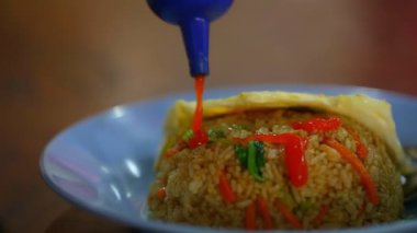 Nasi-goreng 'in geleneksel bale yemeklerini yakından çek, pirincin üzerine ketçap dök.