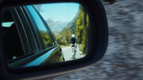 Araba Dikiz Aynasındaki Profesyonel Bisikletçi Dağ Yolunda Bisiklet Sürüyor — Stok video