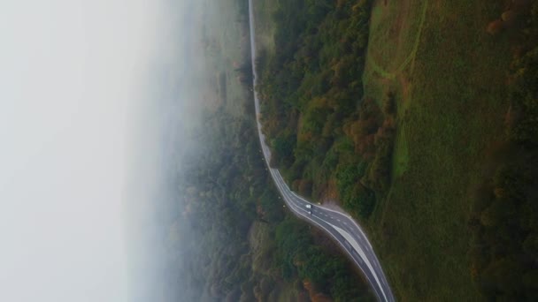 在浓雾笼罩下 孤零零的汽车笼罩在深沉的晨雾中 垂直低垂的低空飞行的秋天清晨山路 — 图库视频影像