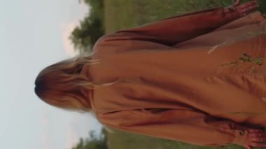 Dikey video romantik kadın çayırda yürüyor