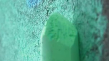 Bir tebeşir parçasının dikey yakın çekimi asfalta çizilir