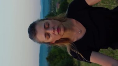 Dağlarda meditasyon yapan sakin bir Yogi kadının dikey video portresi.