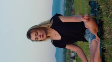 Lotus pozisyonunda yoga yapan dikey videolu kadın.