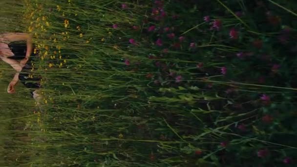 垂直映画ビデオ 花畑に座っている美しい女性のブロンド — ストック動画