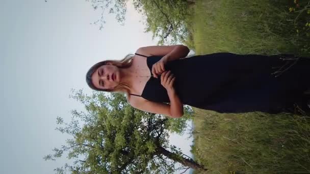 Vertical Vídeo Cinematográfico Hermosa Mujer Rubia Vestido Negro Caminando Cámara — Vídeos de Stock
