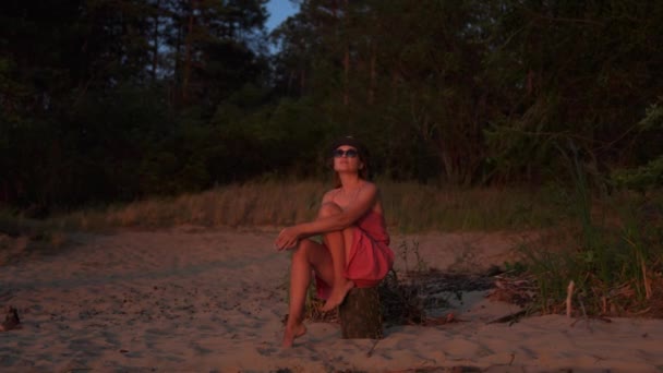 沉思的浪漫女孩坐在树桩上观看日出或日落 — 图库视频影像