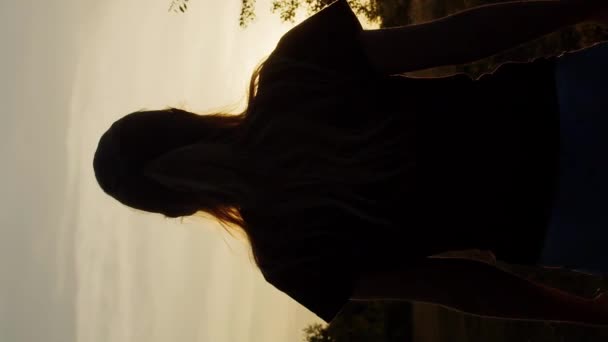 Batan Güneşin Altında Romantik Bir Kadının Dikey Video Silueti — Stok video
