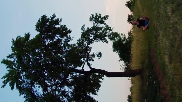 Вертикальное Видео Женщина Практикует Йогу Позе Лотоса Большим Деревом — стоковое видео