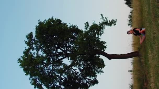 Vídeo Vertical Mujer Practicando Yoga Pose Loto Bajo Gran Árbol — Vídeos de Stock