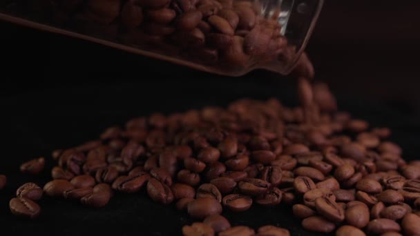 コーヒー豆はコーヒーの表面に落ちるガラス瓶からゆっくりと注ぎます — ストック動画