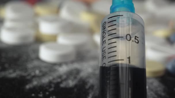 錠剤と医薬品のぼやけた背景を持つ青い危険な液体が付いている閉じた注射器 — ストック動画