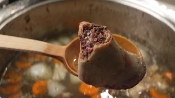 带有胡萝卜和调味品的美味肉汤和碎骨的内部结构 — 图库视频影像