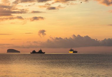 Kargo gemileri gün batımında okyanusa bırakıldı.