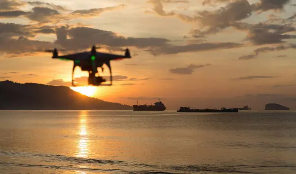 Sabahları okyanusta gün batımında okyanusa bırakılan kargo gemilerini filme alan hava aracı dörtlüsü.