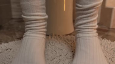 Tuvalette kadınların ayağına külotlar düşüyor. Kadınların bacaklarını yakın plan çekiyoruz. Kadın külotunu çıkarıyor.