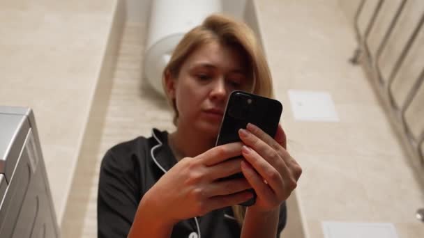 Mulher Loira Sentada Com Smartphone Banheiro Pijama Preto Conceito Gastrite — Vídeo de Stock