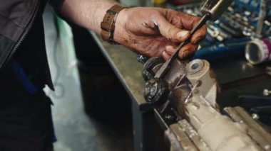 Otomatik tamirci, bozuk bir araba parçasının tamir ve yenilenmesi için direksiyon askısını söker