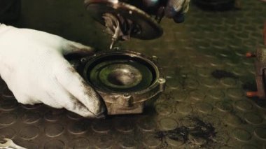 Beyaz eldivenli araba tamircisi arabanın içinde parçalara ayrılır motor parçası türbin pas ve karbon birikintileriyle doludur.
