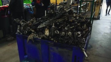 Servis atölyesinde büyük bir sepetteki araba parçaları yığını.